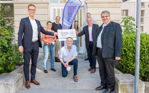 Christoph Unckell (links) übergibt eine Spende von 1.500 Euro an den Vorsitzenden des Fördervereins Wärmestube, Paul Lehrieder. Für den Leiter der Einrichtung, Christian Urban (ganz hinten links), und sein Team, Julia Abler (ganz hinten Mitte) und Andreas Schick (ganz hinten rechts), sind solche Beiträge eine wichtige Unterstützung bei der täglichen Arbeit für die Menschen. Dankbar zeigten sich auch Christophorus-Geschäftsführerin Nadia Fiedler (zweite von links), der stellvertretende Vorsitzende des Fördervereins, Bernhard Christoph (Mitte), und der Vorsitzende des Diözesan-Caritasverbands, Domkapitular Clemens Bieber.