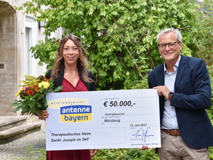 Felicitas Hönes von der Stiftung Antenne Bayern hilft kam mit einem Scheck in Höhe von 50.000 Euro nach Würzburg, um diesen an Dr. Norbert Beck, Leiter des Therapeutischen Heims Sankt Joseph | THSJ im SkF, zu überreichen.